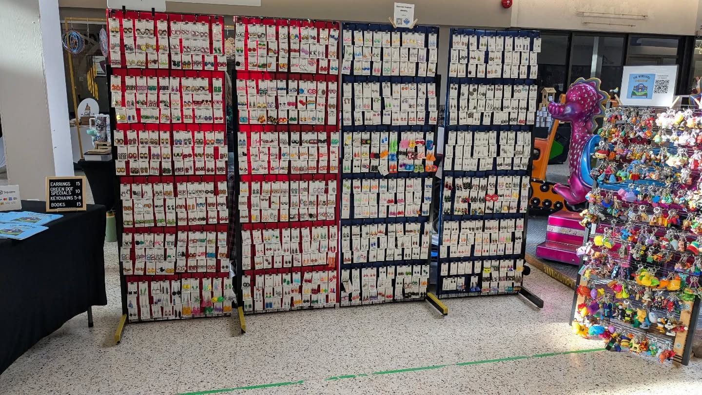 Clearview Creations display wall covered in hundreds of pairs of earrings and keychains